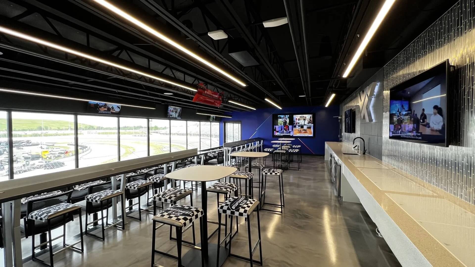 Modern lounge with race track view and seating area.